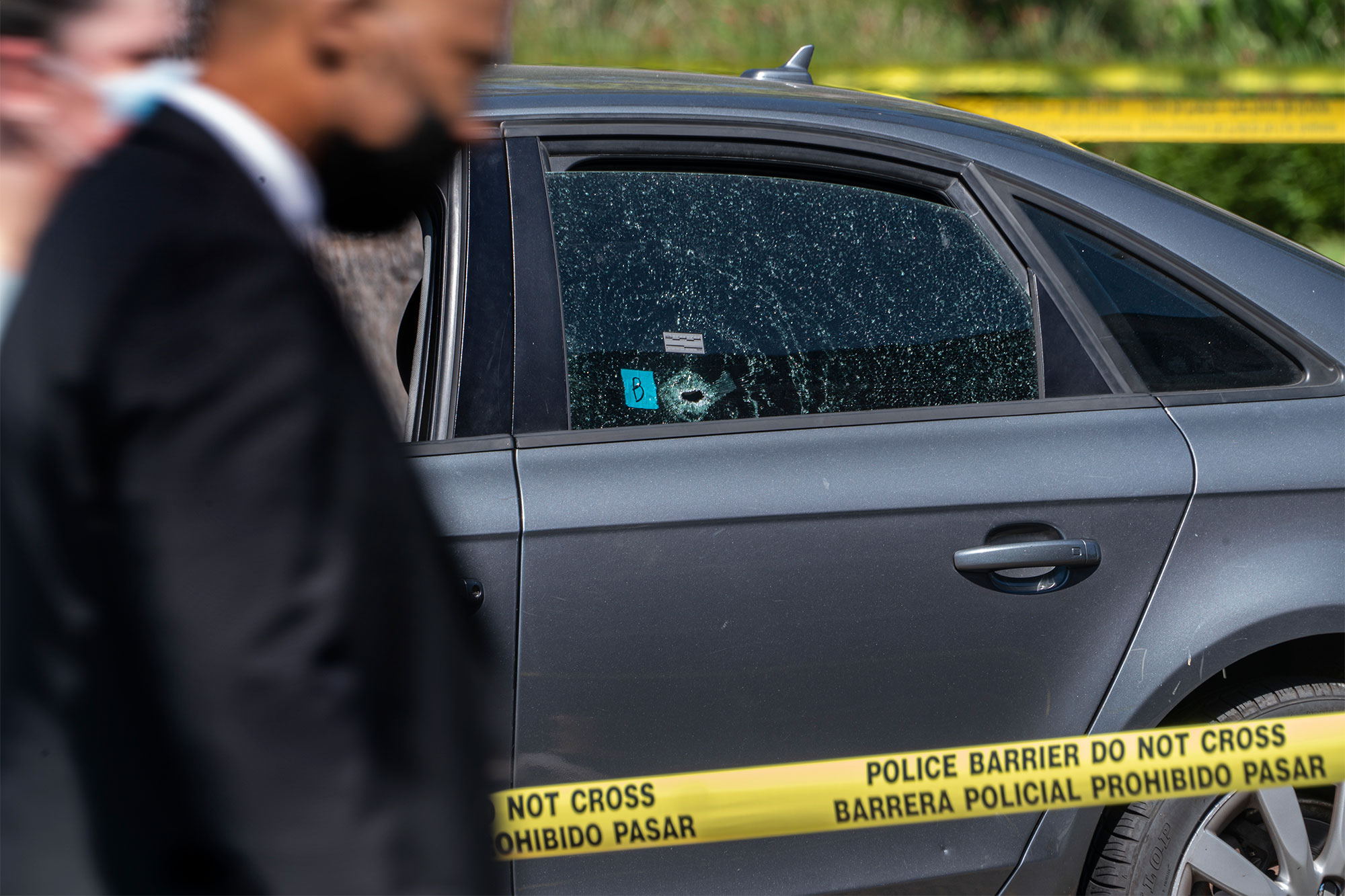 Police investigators walk past a getaway vehicle impacted with bullets in Beverly Hill, Calif., Friday, June 25, 2021. 